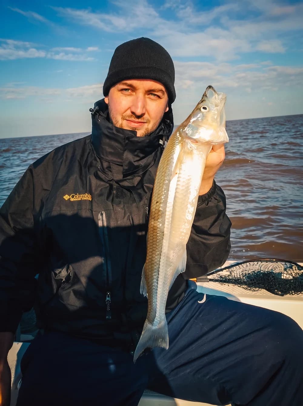 Juan Fontana com um peixe-rei recém-fisgado, pescando de barco no Río de la Plata